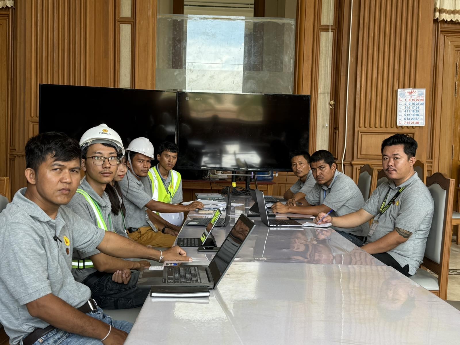 အစည်းအဝေးတွင် laptop နှင့် ပုံများကို ဆွေးနွေးနေသော လုပ်ငန်းခွင်အဖွဲ့